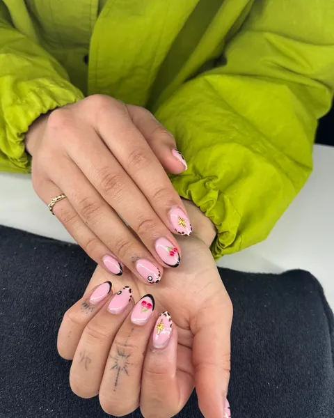 Roze nagels met kersjes, sterretjes en zwarte randen